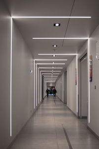 People walking in illuminated corridor of building