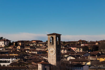 View of buildings in city against clear blue sky