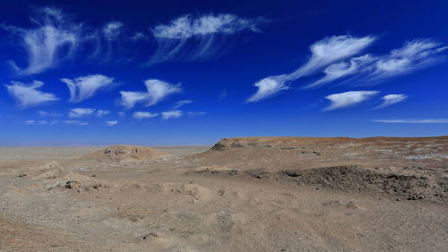 Scenic view of desert against blue sky