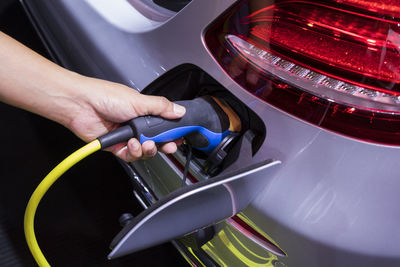 Close-up of hand charging electric car