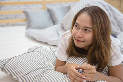 Portrait of girl lying on bed at home