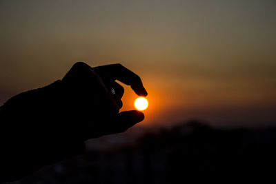 Silhouette man against orange sky during sunset