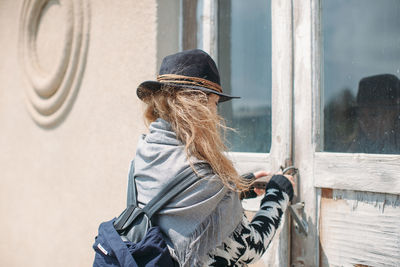 Rear view of woman locking house door