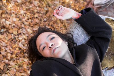 Portrait of young woman with eyes closed lying on field