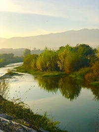 Scenic view of lake against sky at sunset