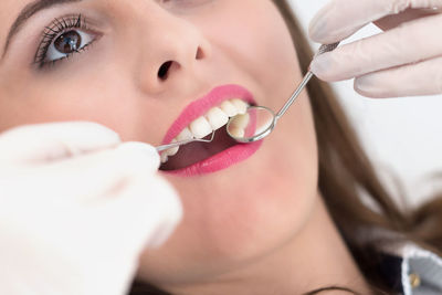 Cropped image of dentist examining woman mouth with dental equipment