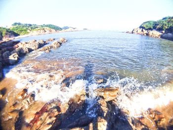 Close-up of wave on beach against clear sky