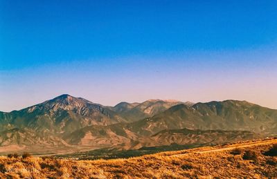 Scenic view of mountains against clear blue sky