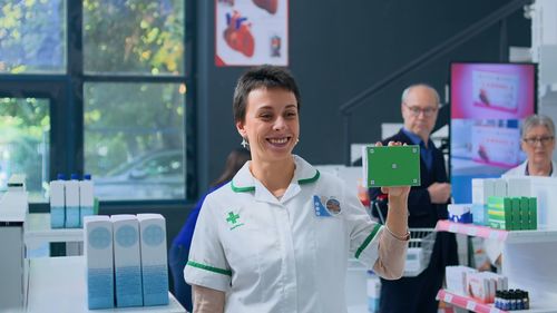 Portrait of young businesswoman using mobile phone while standing in office