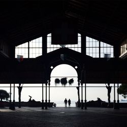 Silhouette people walking on tiled floor