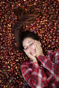 High angle view of woman lying on chestnuts