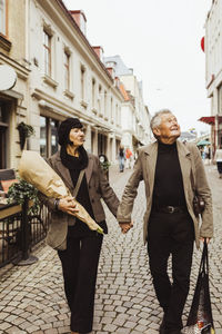 Senior couple holding hands while exploring city during vacation