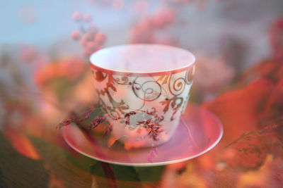 Close-up of cup on table seen through glass