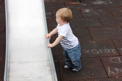 High angle view of cute boy holding slide