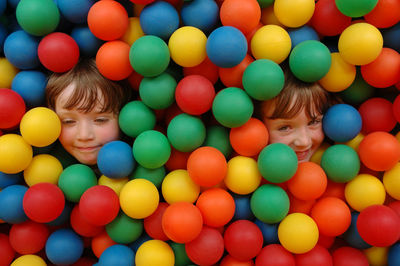 Cute sister and brother surrounded by colorful balls