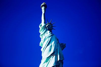 Low angle view of statue against blue sky