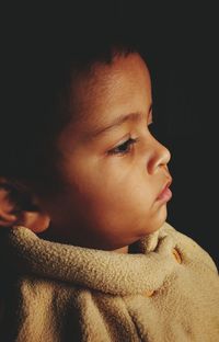 Close-up of cute girl against black background 