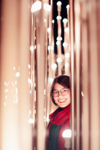 Portrait of asian young woman posing on the decorated lights street at night, christmas, winter