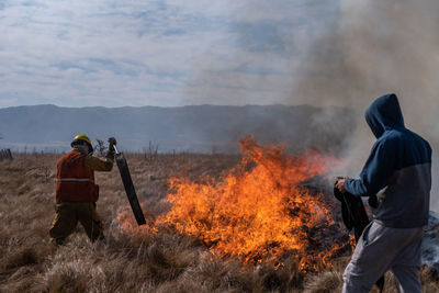 Rear view of men standing on fire