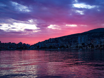 View of sea against buildings at sunset