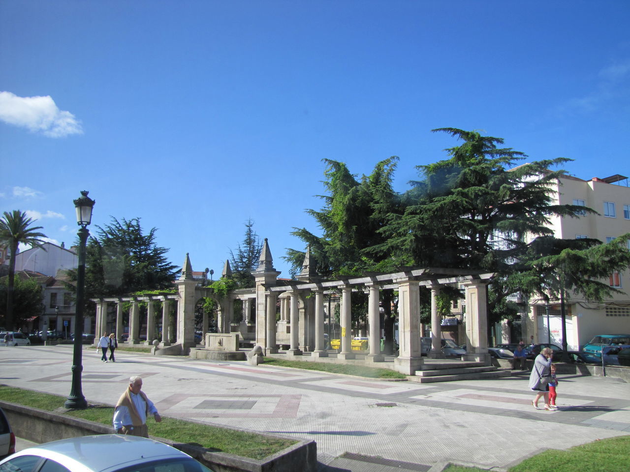 PEOPLE WALKING IN FRONT OF BUILDING AGAINST BLUE SKY