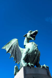 Low angle view of statue against clear blue sky