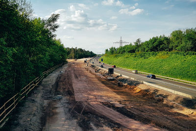 Railroad tracks by road against sky