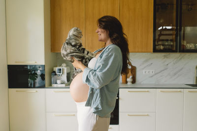 Side view of young woman standing at home