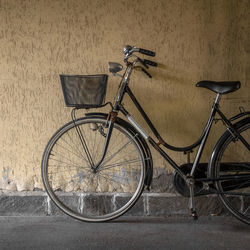 Bicycle parked by wall