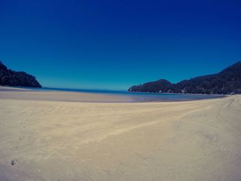 View of calm beach against blue sky