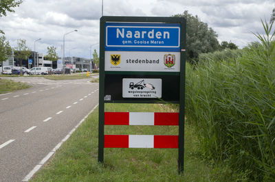 Information sign by road against sky