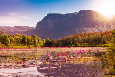 Scenic view of lake by mountain against sky