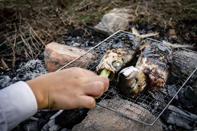 Close-up of person hand on barbecue grill