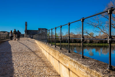 View of canal against clear blue sky