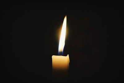 Close-up of lit candle in dark room