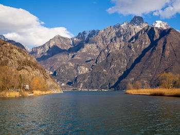 Scenic view of sea by mountains against sky