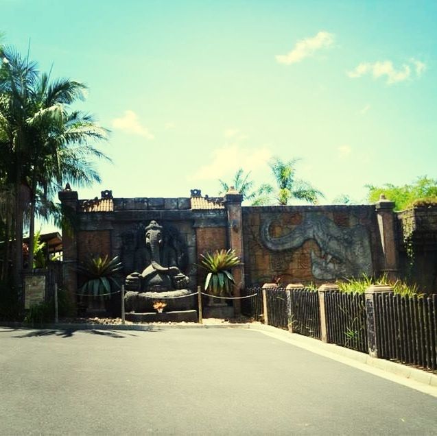 architecture, built structure, building exterior, sky, tree, cloud - sky, house, cloud, wall - building feature, palm tree, day, gate, outdoors, no people, blue, old, sunlight, fence, wall, plant