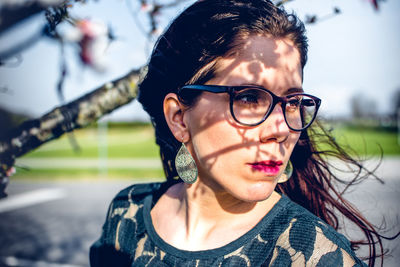 Close-up of woman wearing eyeglasses looking away