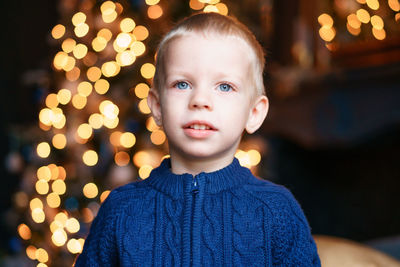 Portrait boy on winter evenings against background christmas lights. excited