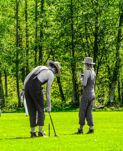 Rear view of men standing on golf course