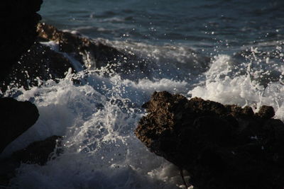 Waves splashing in sea against sky