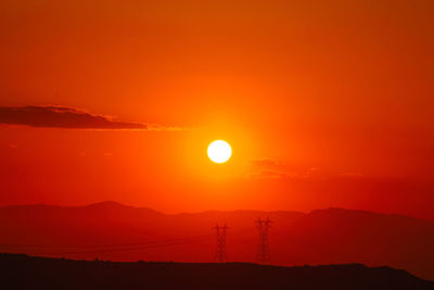 Scenic view of silhouette mountains against romantic sky at sunset