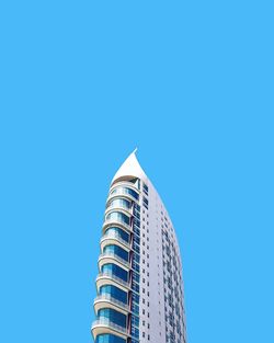 Low angle view of modern building against blue sky