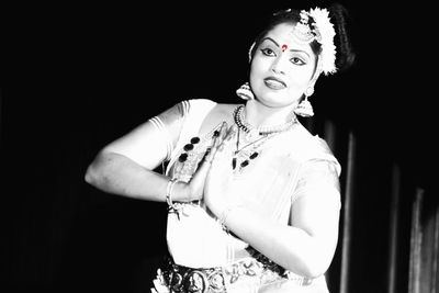 Portrait of mid adult woman over black background