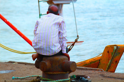 Rear view of man sitting on boat