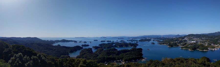 Panoramic view of trees and mountains against clear blue sky