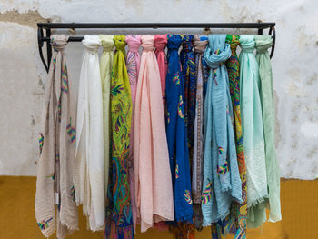 Various clothes hanging on rack against wall