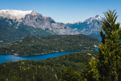 Scenic view of lake by mountains against clear sky