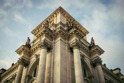 Low angle view of neoclassical building against cloudy sky