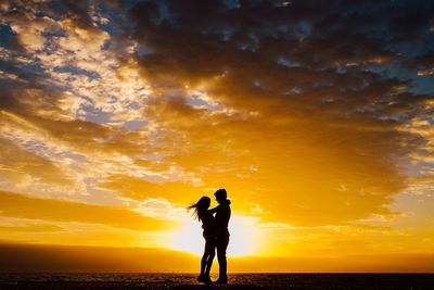 Silhouette people standing on beach against sky during sunset doha qatar